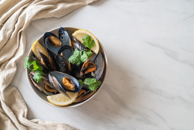 fresh mussels with herbs in a bowl with lemon