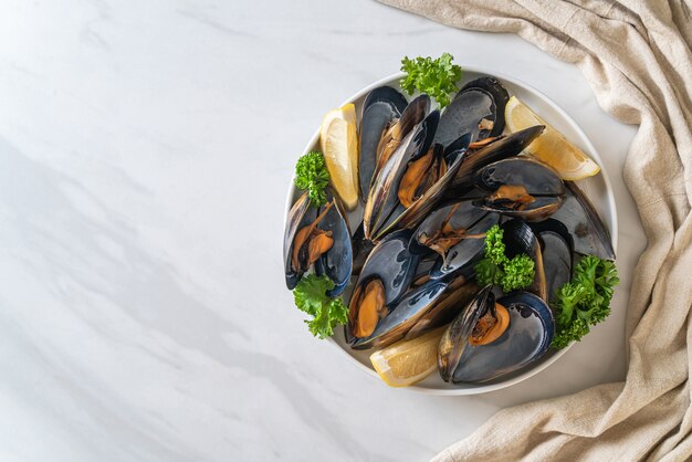 fresh mussels with herbs in a bowl with lemon