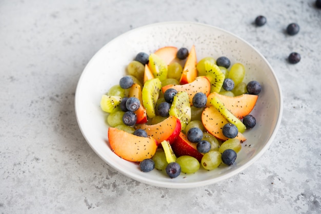 Fresh natural fruit salad bowl with Chia seeds, selective focus