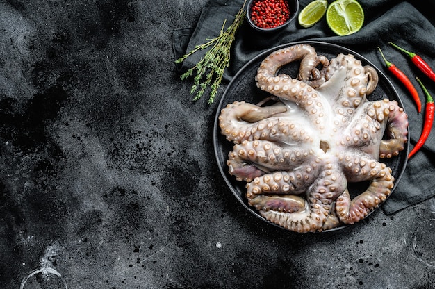 Fresh octopus with cooking ingredients, lime, thyme, chili pepper