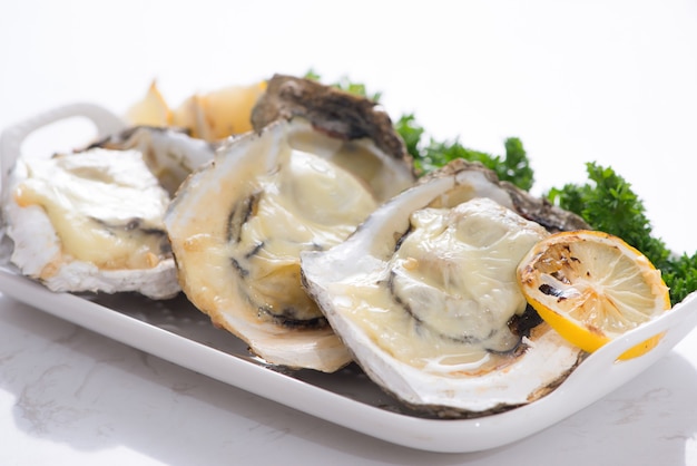 Fresh opened oysters on a white plate. Selective focus