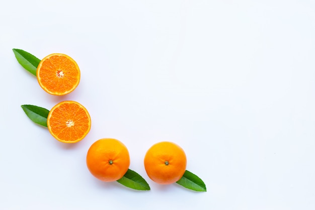 Fresh orange citrus fruit with green leaves on white. 