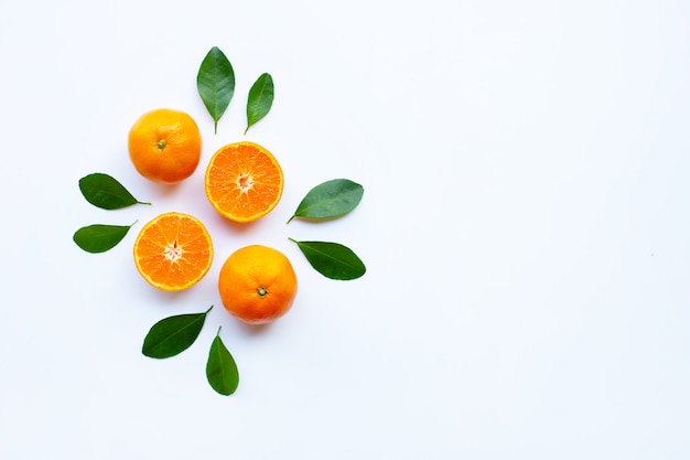 Fresh orange citrus fruit with green leaves on white.