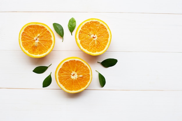 Fresh orange citrus fruit with leaves on white wooden