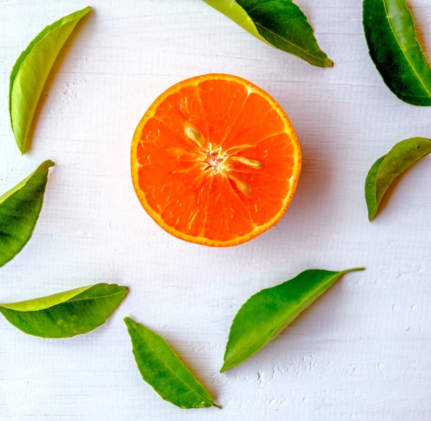 Fresh orange fruit cut in half on white wood background