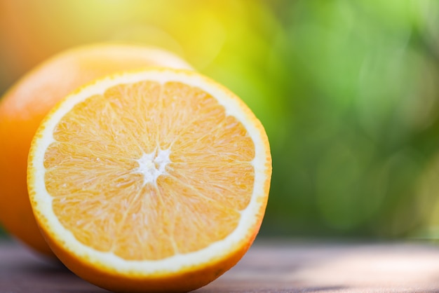 Fresh orange fruit slice half on summer nature background 