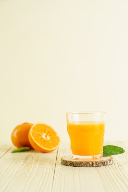 Fresh orange juice on wood background