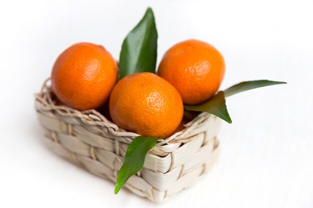 Fresh orange mandarins with leafs in basket