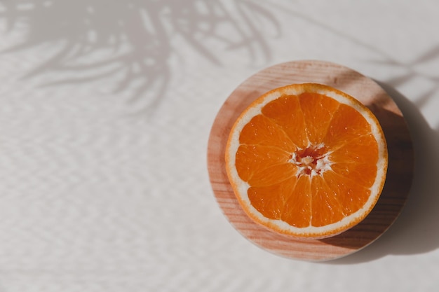 Fresh orange Sliced fruit on a wooden ecological plate isolated on white table backgrounds Healthy raw food concept Flat lay top view