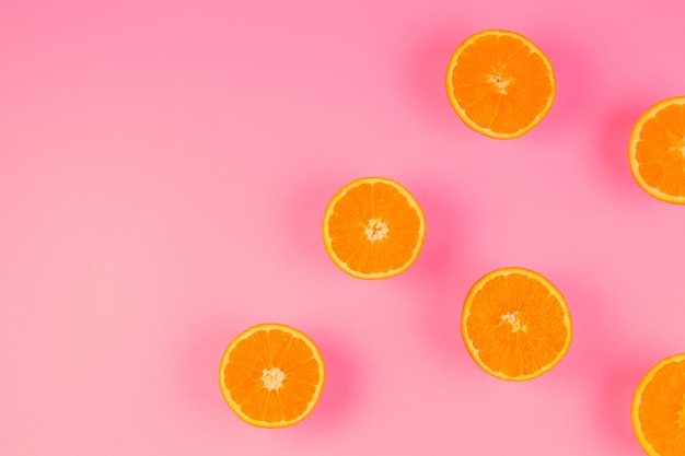 Fresh orange slices on pink background top view