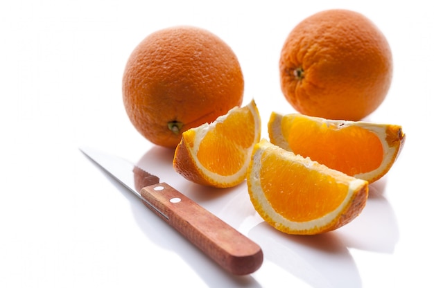 Fresh oranges and knife. Isolated composition on white with shadow.