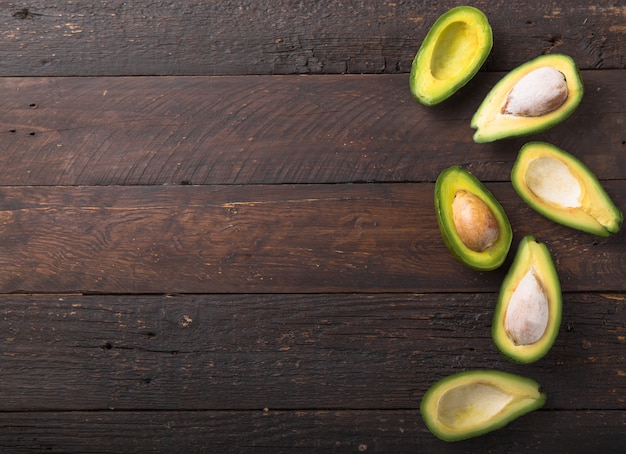 Fresh organic avocado halves on old wooden table