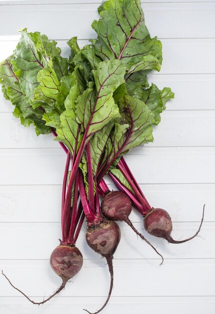 Fresh organic beetroot with leaves root vegetables over wooden background top view