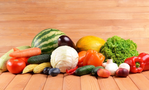 Fresh organic fruits and vegetables on wooden background