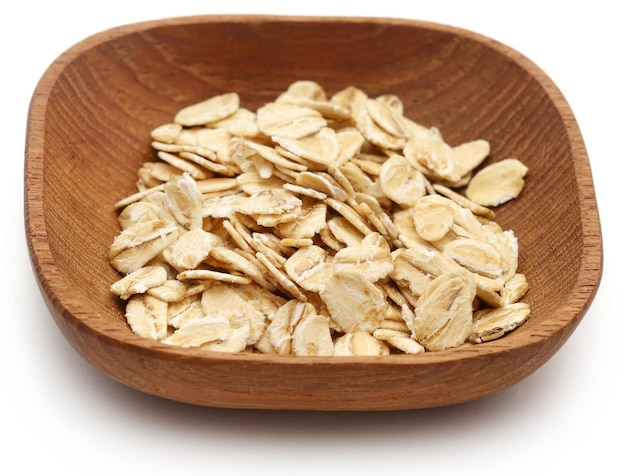 Fresh organic oats in a bowl isolated over white background