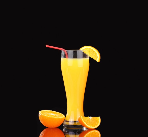 Fresh organic orange juice and vodka in a tall glass on black