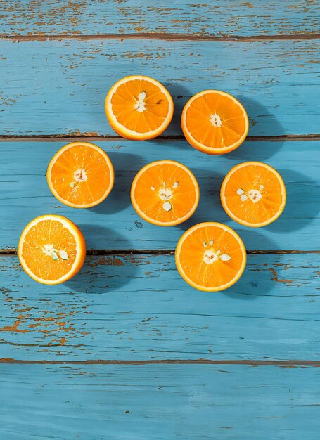 Photo fresh organic oranges halves fruits on blue wooden background with copy space