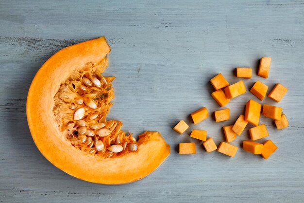 Fresh organic pumpkin slice and diced on a light blue wooden table. Jam making