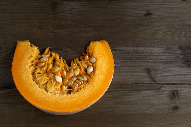 Fresh organic pumpkin slice with seeds on a dark background Harvest day