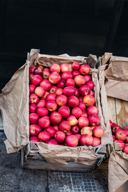 Fresh organic red apples are in wooden crate at bazaar