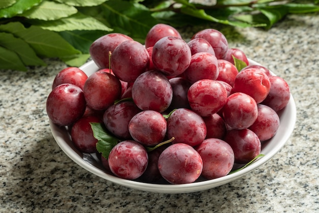 Fresh organic red plums in bowl