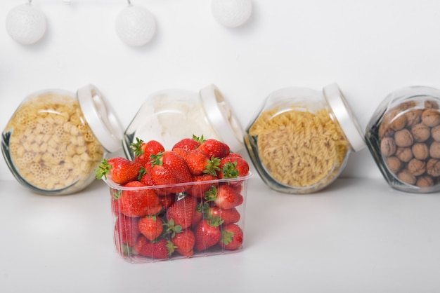 Fresh Organic Strawberries In A Plastic Box In The Kitchen. delivery of organic products. packaging of organic strawberries.