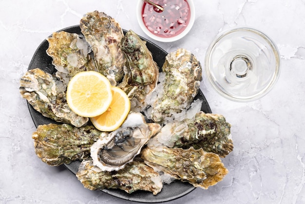 Fresh oysters with sauce and lemons