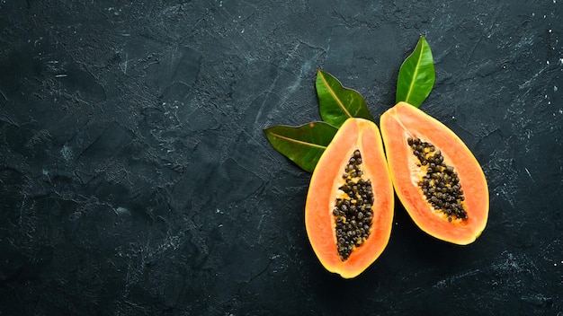 Fresh papaya on a black stone background Tropical Fruits Top view Free space for text