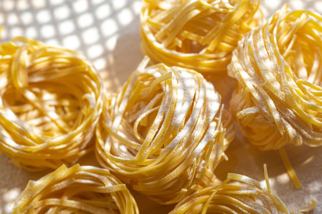 Fresh pasta food. Homemade Italian pasta cooked on a wooden table in a rustic style decorated with egg and flour.