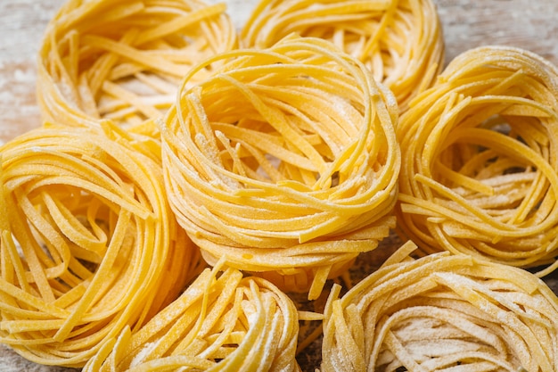 Fresh pasta food. Homemade Italian pasta cooked on a wooden table in a rustic style decorated with egg and flour.