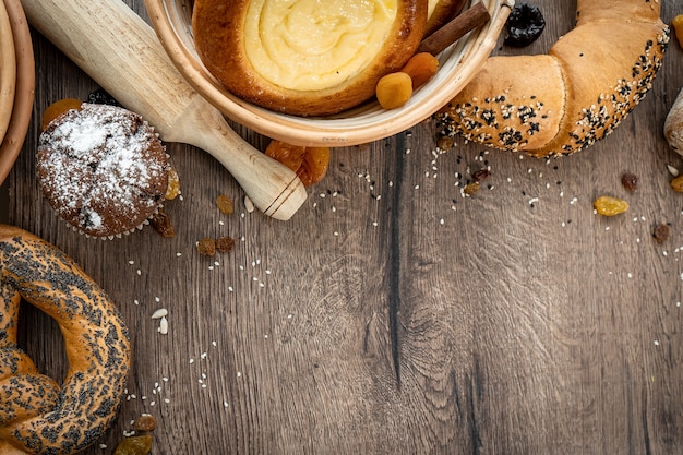 Fresh pastries buns in the basket in rustic style bakery with eggs and gluten on wooden table