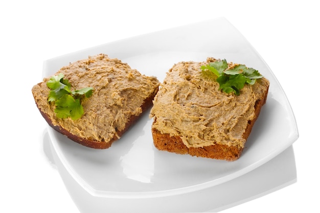 Fresh pate on bread on white plate isolated on white