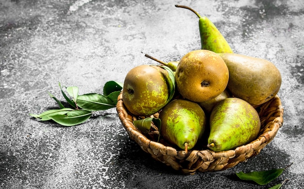 Fresh pears in a basket. On a rustic table.