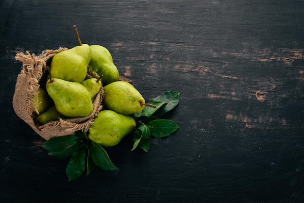 Fresh pears A large set of pears Fruits Free space for text On a black wooden background Top view