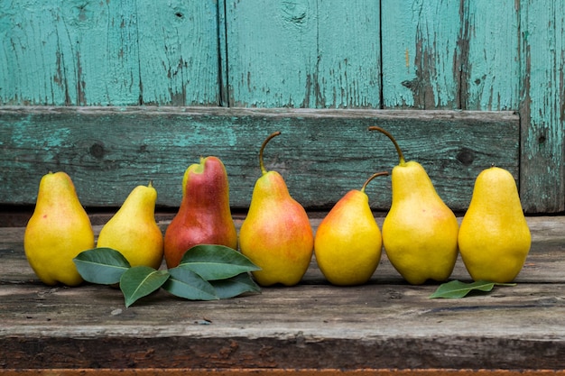 Fresh pears with leaves on the dark rustic wooden table