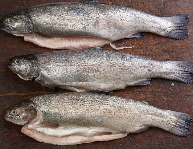 Fresh peeled trout fish on a brown cutting board