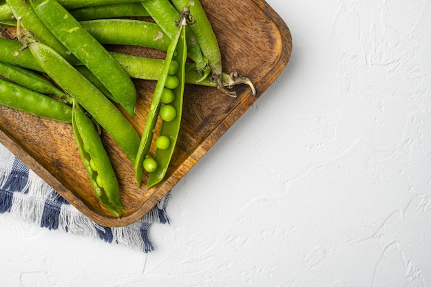 Fresh picked green pea on white stone table background top view flat lay with copy space for text