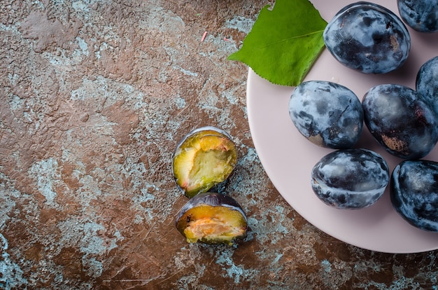 Fresh picked plums in ceramic plate 