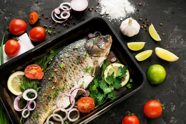 Fresh pickled fish seasoned with spices on a dark background