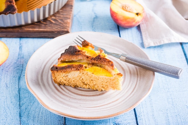 Fresh piece of peach pie and fork on a plate on the table Homemade pastries