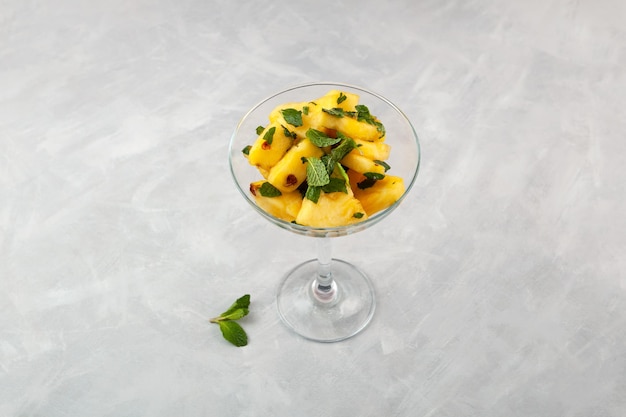 Fresh pineapple in cane sugar syrup with mint leaves Traditional Asian dessert chinese fruit salad