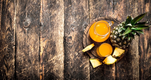 Fresh pineapple juice on wooden table.