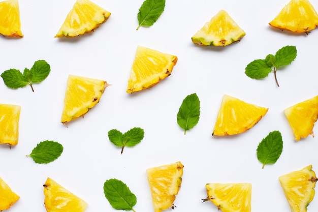 Fresh pineapple slices with mint leaves on white