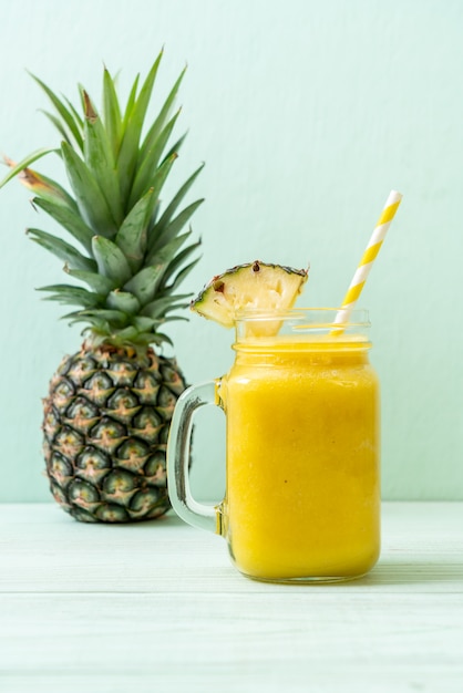 fresh pineapple smoothie glass on wood table