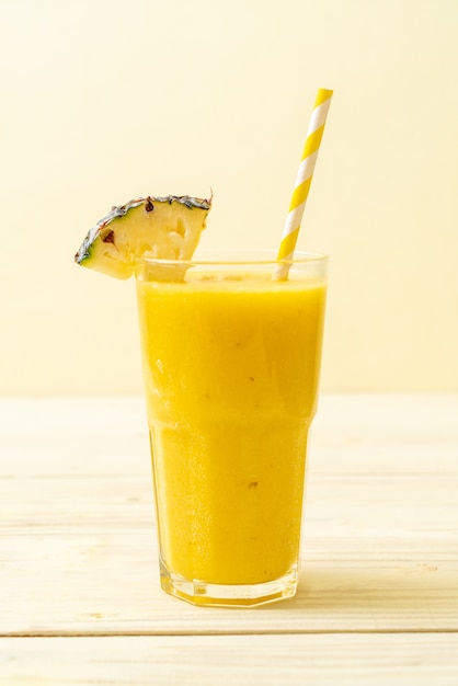 fresh pineapple smoothie glass on wood table