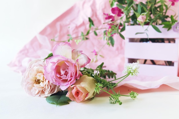 Fresh pink roses in a basket flowers on a light background the concept of a romantic greeting