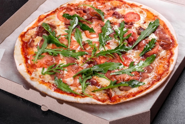 Fresh pizza baked in oven with arugula, salami, cherry tomatoes and mozzarella. Italian cuisine