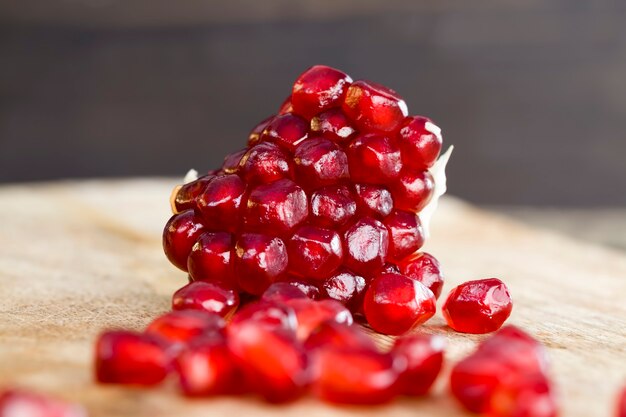 Fresh pomegranate closeup, red and ripe fruit pomegranate with red grains, delicious and healthy pomegranate divided into several parts with red seeds