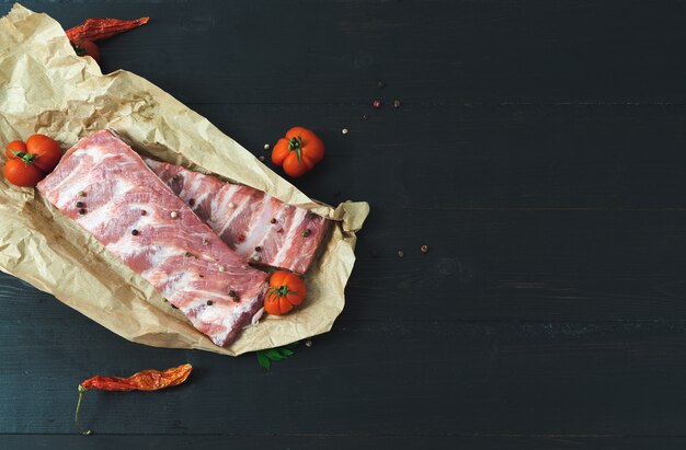 Fresh pork ribs on a dark background. Copy space.