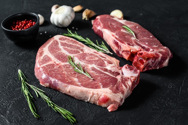 Fresh pork steak. Marbled meat. Black background. Top view